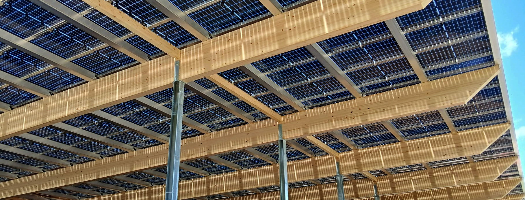 Unteransicht einer Photovoltaik-Überdachung mit Solarmodulen und Montagesystem.